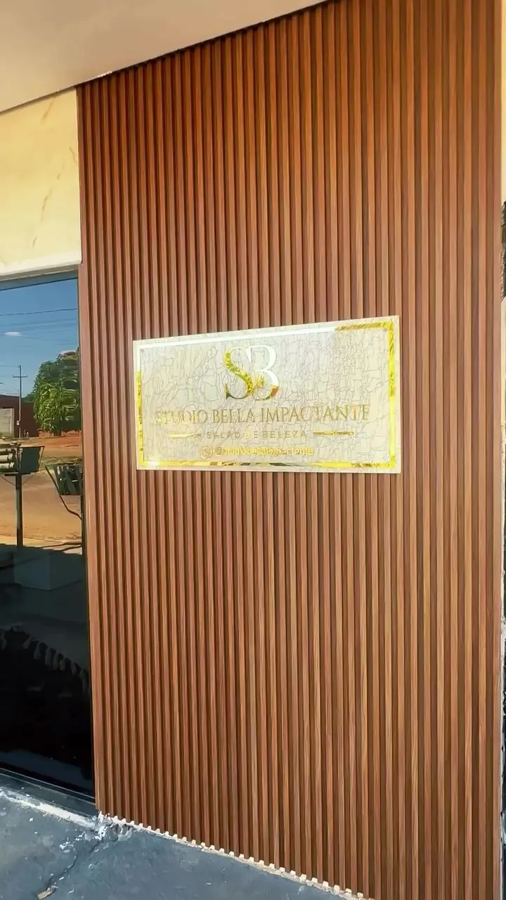 Fachada do Studio Bella Impactante com ripado de madeira e placa dourada com o monograma SB