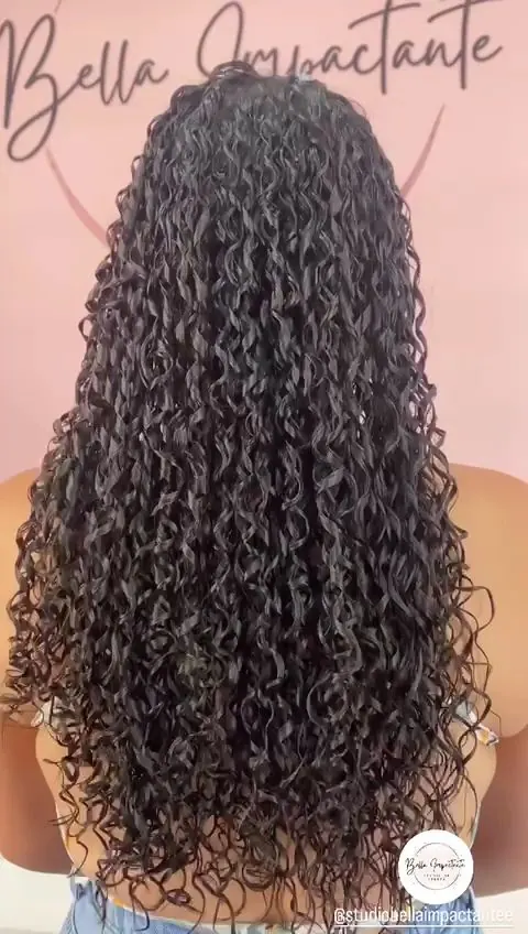 Cabelo longo com cachos pequenos e definidos, visto de costas diante de parede rosa