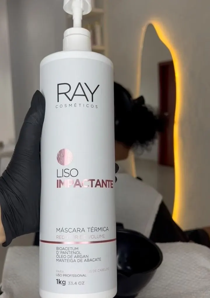 Frasco da máscara térmica Liso Impactante, da RAY Cosméticos, segurado por mão de luva preta no salão