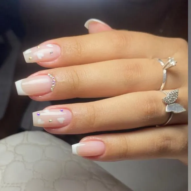 Unhas longas em tom nude com francesinha e decoração de pedrarias